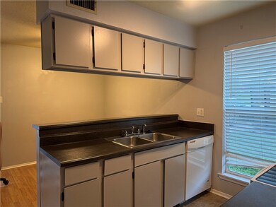 Kitchen featuring dishwasher, dark countertops, li