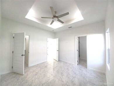 Unfurnished bedroom featuring a tray ceiling, a closet, a walk in closet, visible vents, and marble finish floor