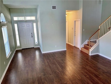 Foyer entrance with stairway, dark wood-style flo
