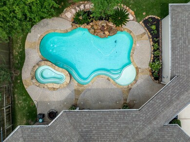 Backyard oasis with pool/spa, rock waterfall, and large covered porch.