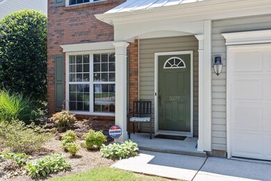 Doorway to property with brick siding, a garage, and a standing seam roof