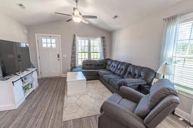 Living area featuring visible vents, light wood-st