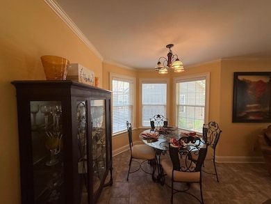 Dining space featuring ornamental molding, dark ti