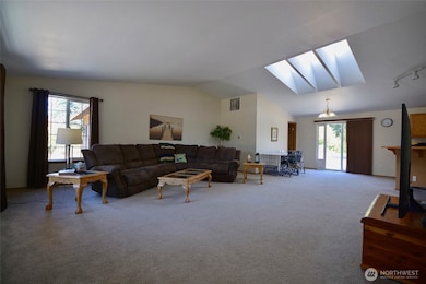 The home offers an open space concept for the main living areas. There's room to hoast a lot of friends for game night or just cozy up at home with family members. The spacious dining area is located opposite the kitchen.  Large windows, triple skylights and patio sliders all ad light even on gloomy winter days.