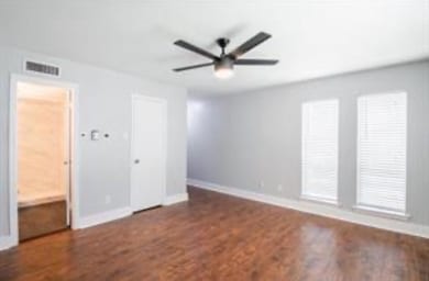 Unfurnished room featuring baseboards, wood finish