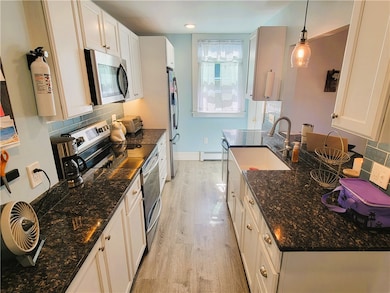 Modern galley kitchen with breakfast bar and stone countertops