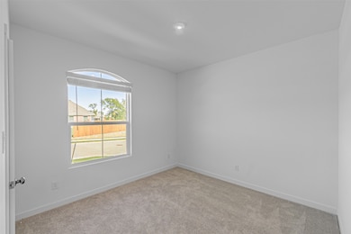 Spare room featuring light colored carpet and baseboards