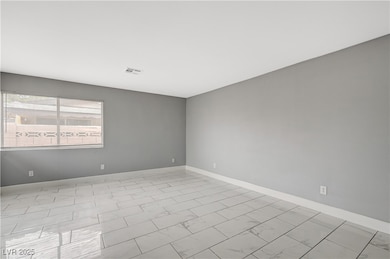 Unfurnished room featuring baseboards and light marble finish flooring