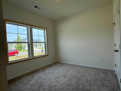 Empty room featuring carpet and baseboards