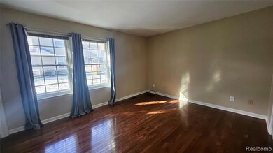 Unfurnished room featuring baseboards and dark wood finished floors