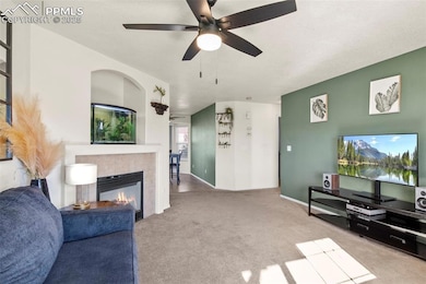 Carpeted living room featuring a tiled fireplace a