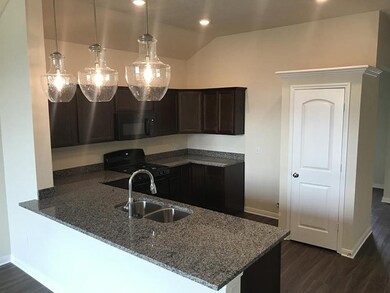 Kitchen with a peninsula, black appliances, a sink