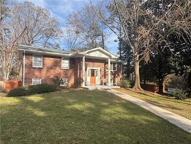 Split foyer home with a front lawn and brick sidin