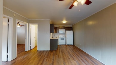 Kitchen with a sink, light countertops, ceiling fa