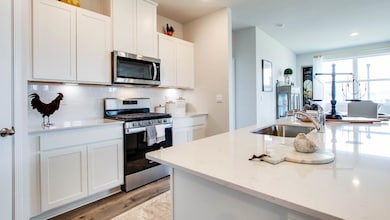 Kitchen featuring white cabinetry, decorative back