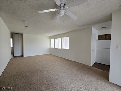 Spare room featuring a textured ceiling and carpet