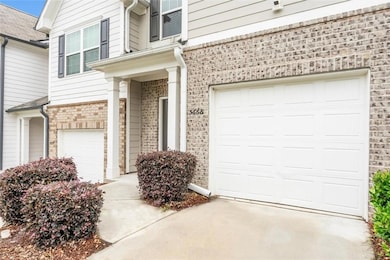 Property entrance with brick siding, driveway, and a garage