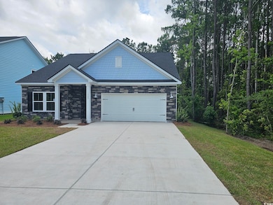 Craftsman-style house with concrete driveway, a front yard, a garage, and stone siding