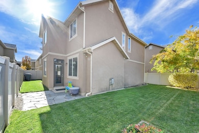 Rear view of property with a fenced backyard, stucco siding, and a patio area