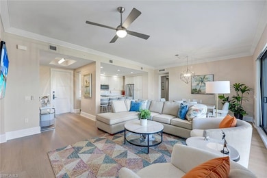 Living area with crown molding, ceiling fan with n