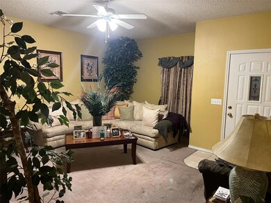 Carpeted living room with ceiling fan and a textur