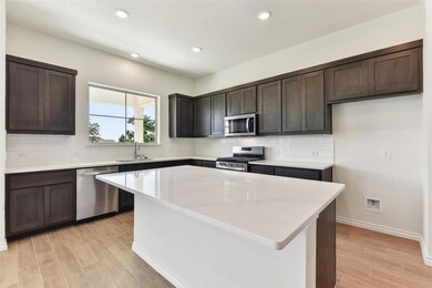 Kitchen featuring dark brown cabinetry, stainless