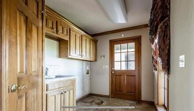 Entryway featuring sink, ornamental molding, and light tile floors