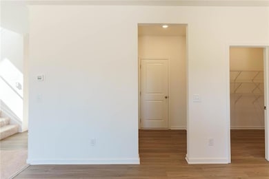 Spare room featuring baseboards, stairway, and woo
