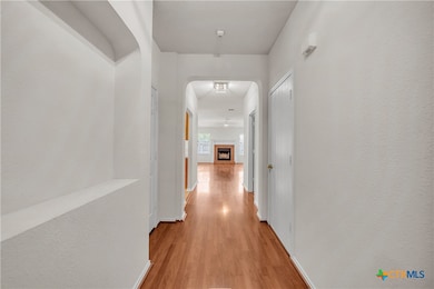 An arched art nook and arched entry provides a wel