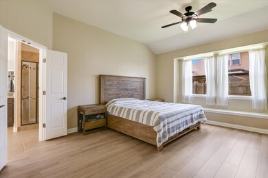 Bedroom with vaulted ceiling, light wood-style fl