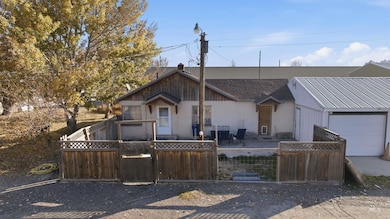View of front of house with a patio, a fenced front yard, an attached garage, and a gate