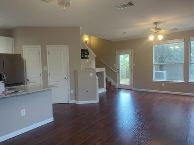 Unfurnished living room featuring ceiling fan, dark wood finished floors, and stairway