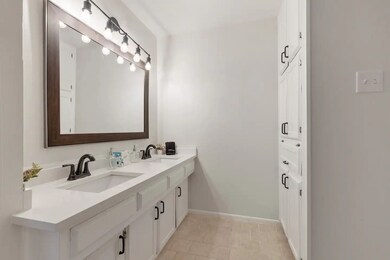 Bathroom featuring double vanity and light tile patterned flooring