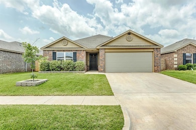 View of front of home with brick siding, an attached garage, driveway, and a front yard