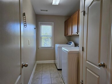 Upstairs laundry room with built in cabinets for added convenience