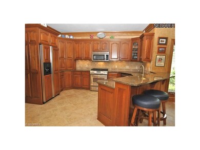 Open kitchen has Schrock cherry cabinetry, travert