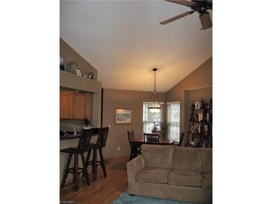 Vaulted great room with ceiling fan showing kitche