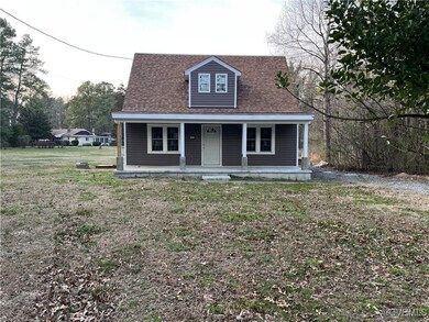 View of front of house with a porch and a front ya