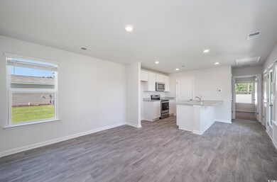 Kitchen featuring an island with sink, sink, white