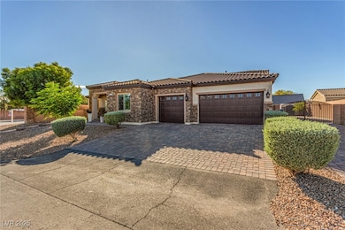 View of front of home featuring decorative driveway, an attached garage, stone siding, stucco siding, and a tiled roof