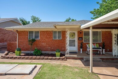Entrance to property with brick siding, covered porch, and a shingled roof