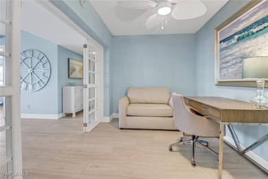 Office space featuring wood finished floors, ceiling fan, and french doors