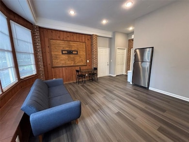 Living area featuring wooden walls, dark wood-type flooring, and recessed lighting