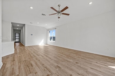 Spare room featuring light wood finished floors, recessed lighting, a ceiling fan, and lofted ceiling