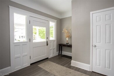 Foyer entrance featuring engineered hardwood flooring and a wealth of natural light