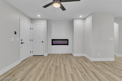 Unfurnished living room with ceiling fan, a firepl