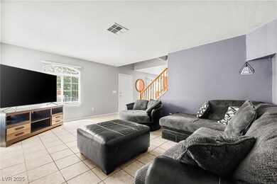 Living area featuring stairs and light tile patter