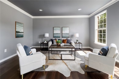 Hardwood floored living room featuring crown moldi