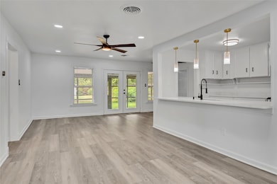 Unfurnished living room featuring recessed lighting, light wood-style flooring, french doors, and ceiling fan