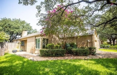 Back of house with brick siding, a patio, and a chimney